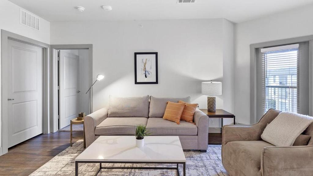ein Wohnzimmer mit einem Sofa und einem Tisch in der Unterkunft Landing Modern Apartment with Amazing Amenities (ID1802X99) in Haltom City