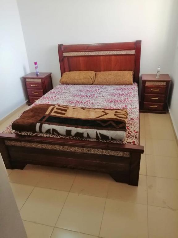 a bedroom with a bed with two night stands and two tables at Appartement Jardin d'Ifrane in Ifrane