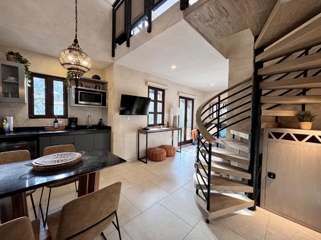 a kitchen and dining room with a spiral staircase at Loft Amalfi en Val'Quirico in Santeagueda