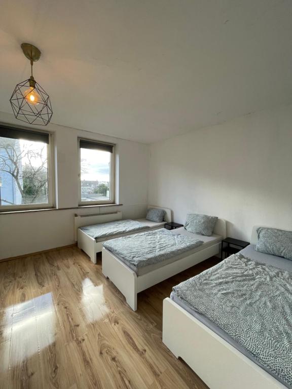 Cette chambre comprend trois lits et deux fenêtres. dans l'établissement Wohnung in Stadtnähe Düren, à Düren