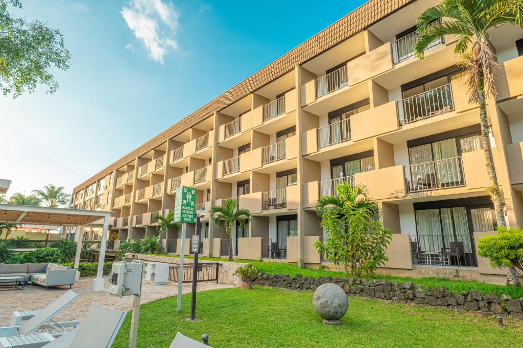 an exterior view of a hotel with palm trees at Irazú Hotel & Studios in San José