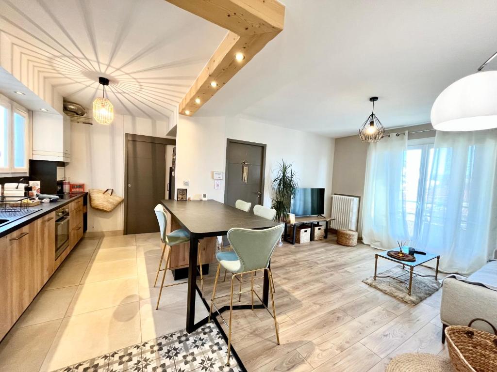 une cuisine et un salon avec une table et des chaises dans l'établissement Appart’ Chaleureux avec balcon/800m Gare et centre, à Valence