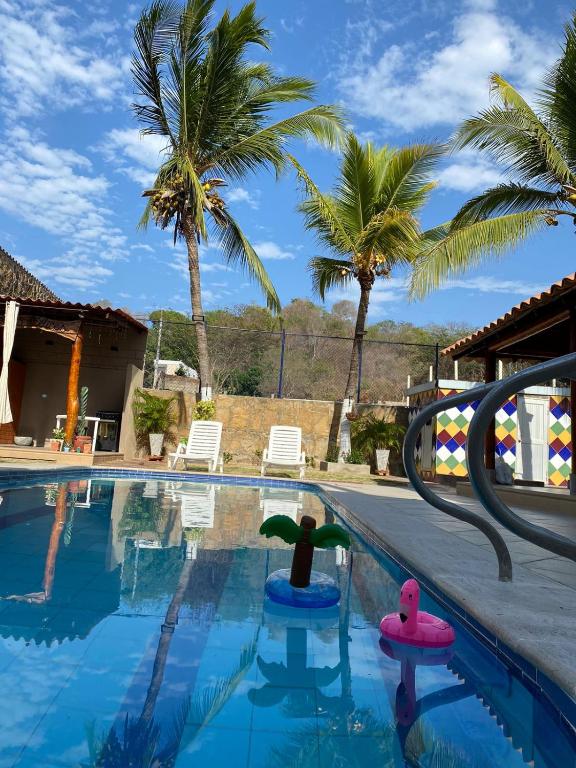 una piscina con dos patos de goma en el agua en Palma House - Cabaña con piscina, en Tubará