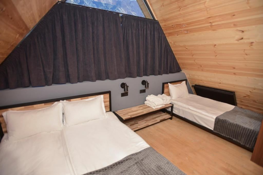 Cette petite chambre comprend 2 lits et une fenêtre. dans l'établissement Kazbegi Story, à Kazbegi