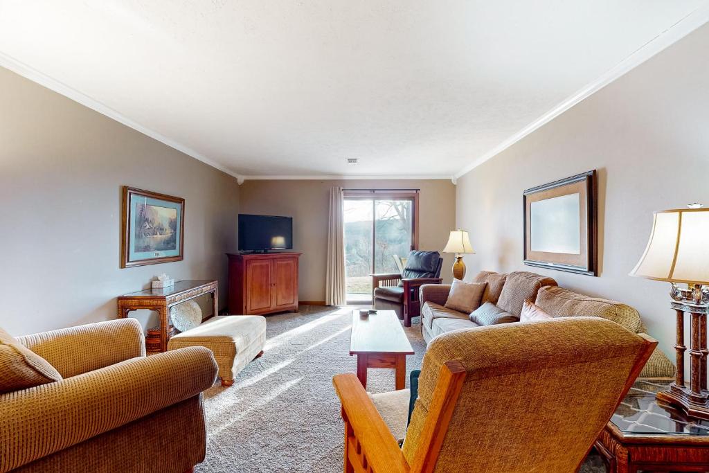 a living room with couches and a tv at Minutes from Everything in Branson