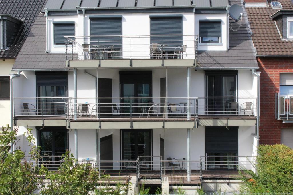 ein weißes Apartmenthaus mit Balkonen und Fenstern in der Unterkunft Apartment Wesseling Zentrum Nauerz in Wesseling