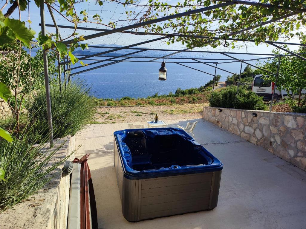 a blue tub sitting on a sidewalk near the water at House Galisnjak with jacuzzi in Bol