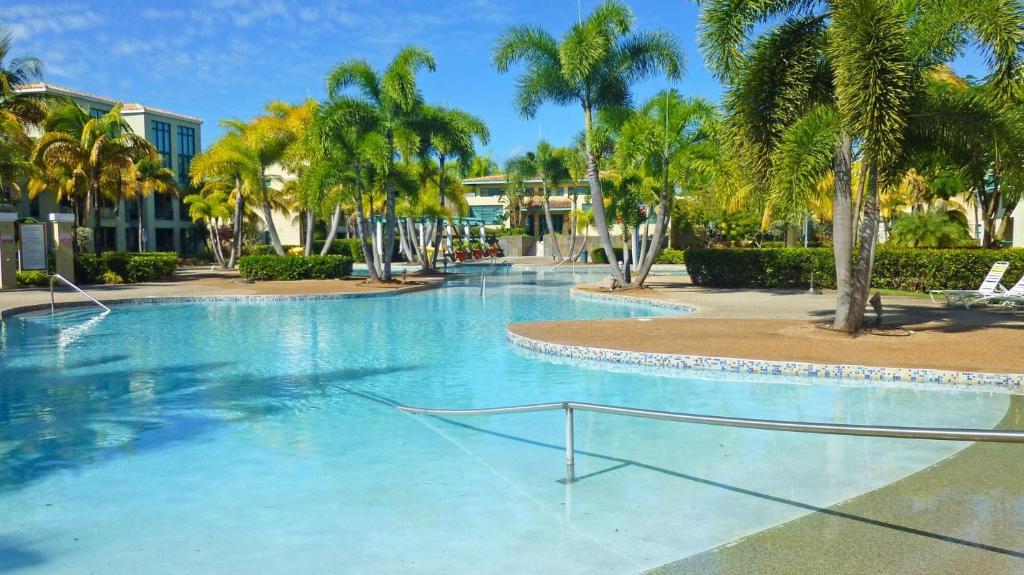 uma grande piscina com palmeiras num resort em Sandy Cove em Río Grande