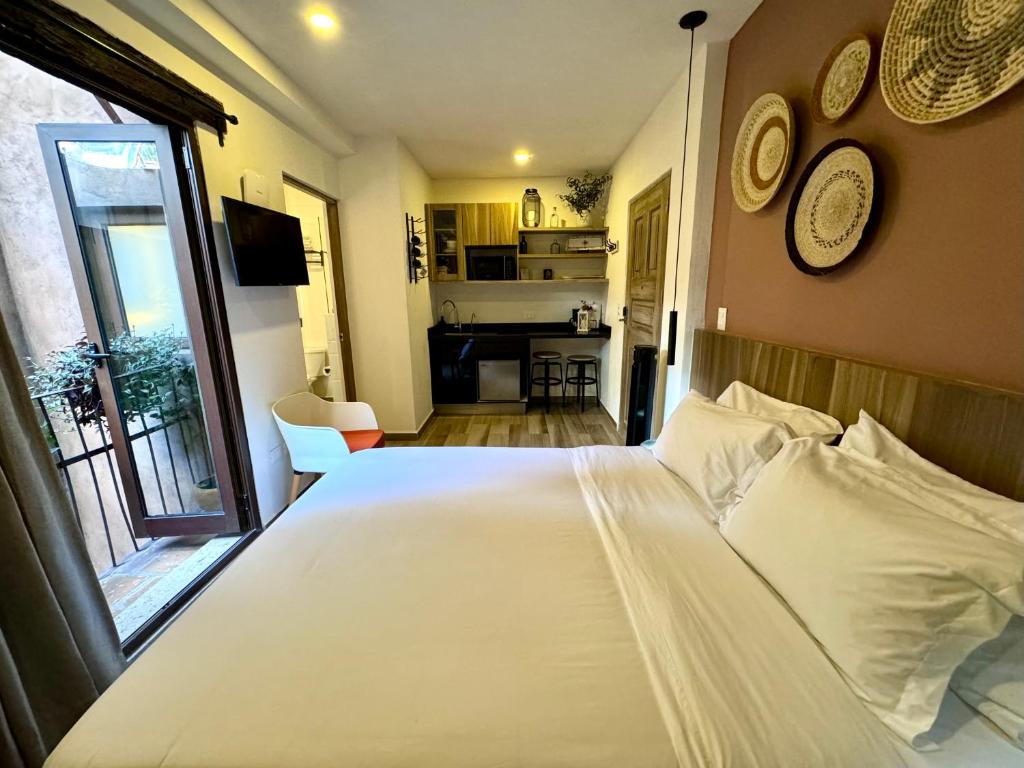1 Schlafzimmer mit einem großen weißen Bett und einer Küche in der Unterkunft Val'Quirico Lucca 84 Loft Toscano in Santeagueda