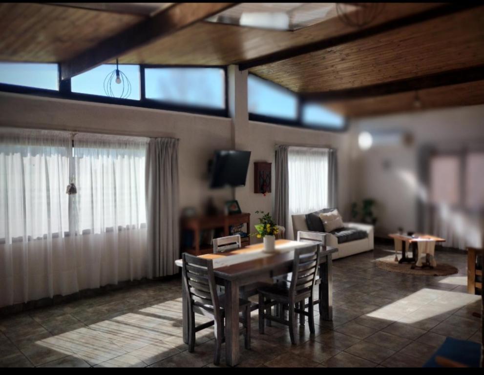 a living room with a wooden table and chairs at Amapola in Balneario Mar Chiquita