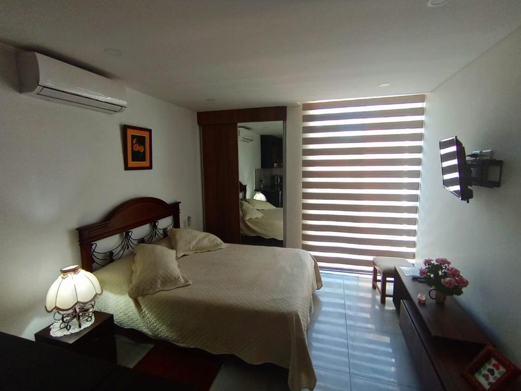 ein Schlafzimmer mit einem Bett und einem großen Fenster in der Unterkunft Monoambiente Vintage Las Palmas in Santa Cruz de la Sierra