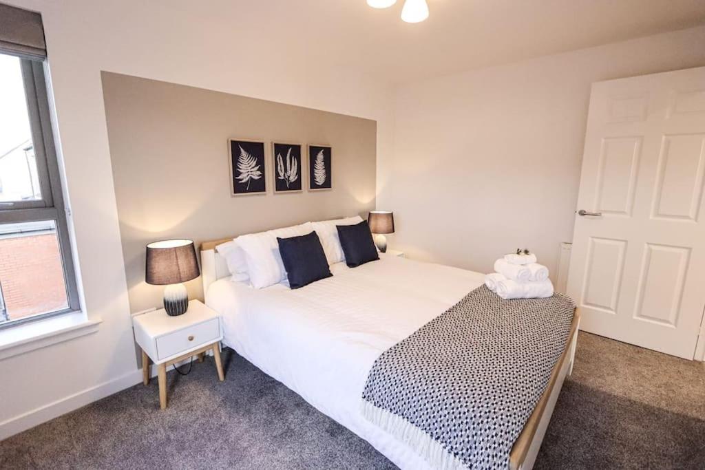 Un dormitorio con una gran cama blanca y una ventana en City Views by the Castle, Free Designated Parking., en Stirling