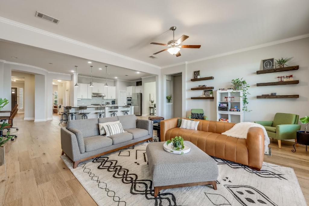 a living room with two couches and a kitchen at Immaculate, family friendly home in SW Austin in Austin