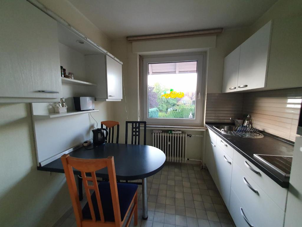 a small kitchen with a table and a window at Privatzimmer direkt an der Uniklinik Mainz in Mainz