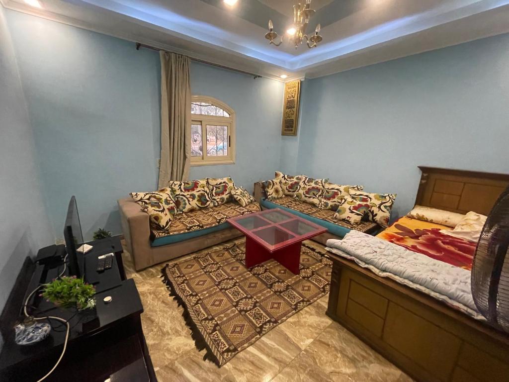 ‘Ezbet el-Insha的住宿－شقه متميزه بالحي التاسع，客厅配有两张床和一张桌子