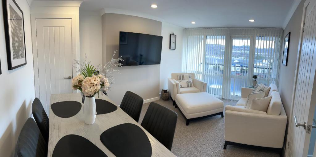 a dining room with a table and a living room at Glenshellach Apartment Oban in Oban