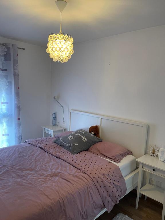 um quarto com uma cama e um lustre em Cerisier em Ségny