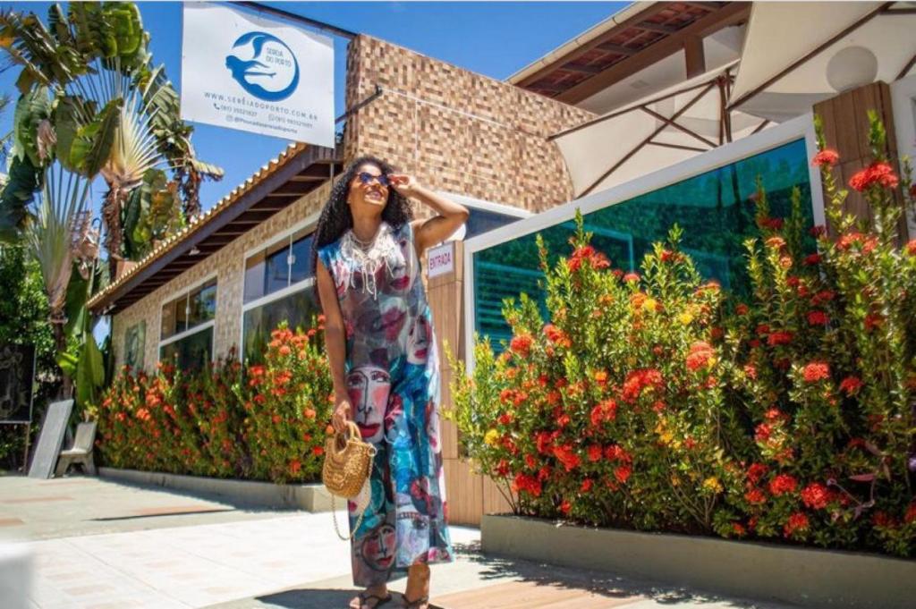 a woman standing in front of a building at Pousada Sereia do Porto in Porto De Galinhas