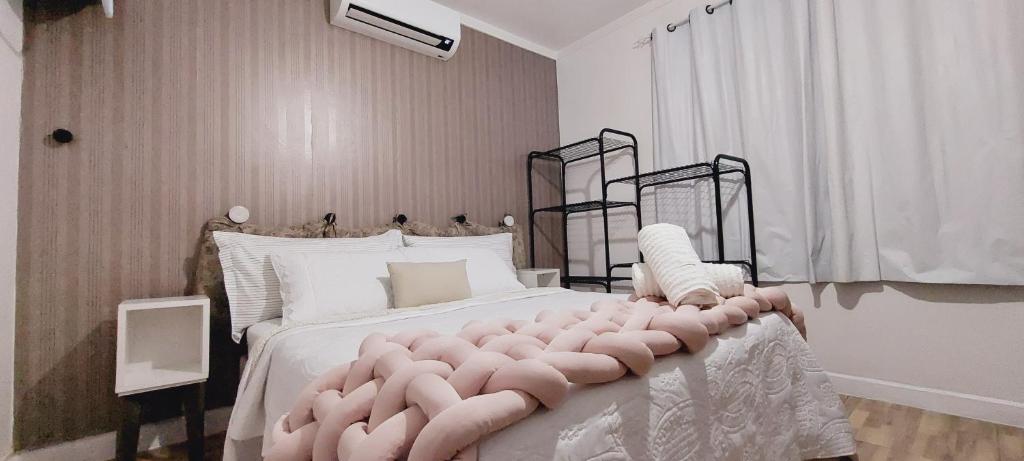 um quarto com uma cama grande e uma cabeceira de cama rosa tufada em Apto Essepê! Expo Center Norte, Rodoviaria Tiete e Brás Vautier em São Paulo