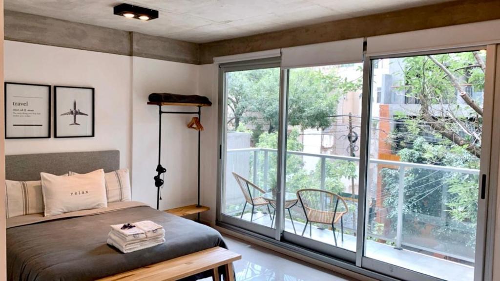 um quarto com uma cama e uma grande janela em Amazing Apartment in Palermo Hollywood! With Balcony em Buenos Aires