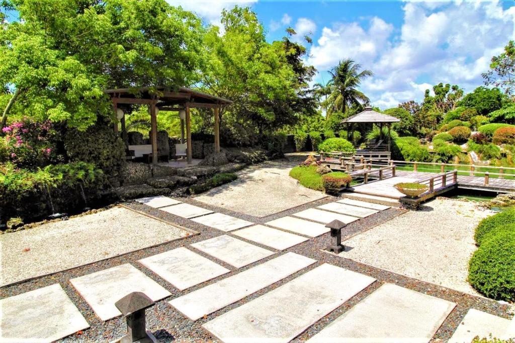 einen Garten mit einer Bank und einem Pavillon in der Unterkunft Exotic Sukiya Tiny House Japanese Balinese Gardens in Homestead