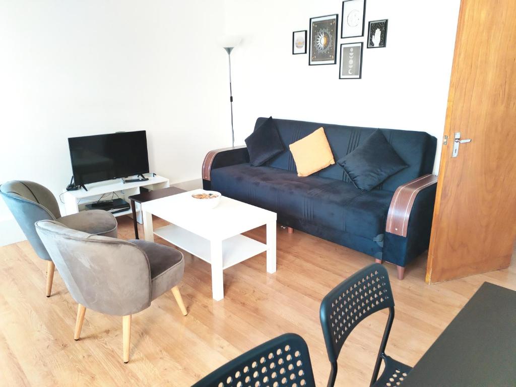 uma sala de estar com um sofá, cadeiras e uma mesa em Cosy central London Apartment, EC1V em Londres