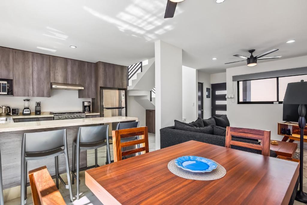 Coastal Comfort Haven في نويفو فايارتا: مطبخ وغرفة معيشة مع طاولة خشبية