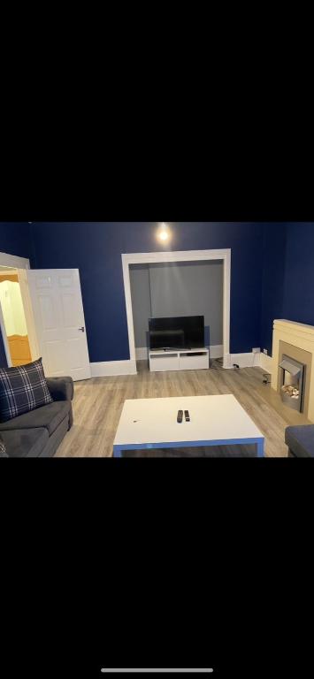 a living room with a couch and a table at Town centre apartment in Motherwell
