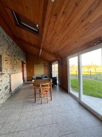 une salle à manger avec une table et une grande fenêtre dans l'établissement Maison de famille, à Pré-en-Pail