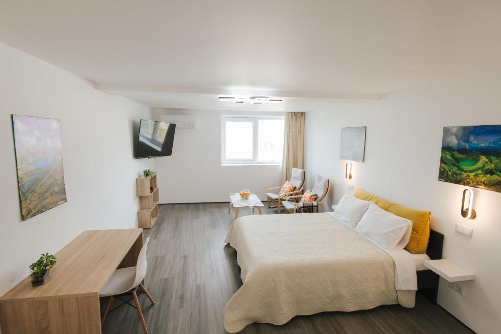 una camera d'albergo con letto, tavolo e scrivania di Spacious Seaside apartment A - Faraway a Lagoa