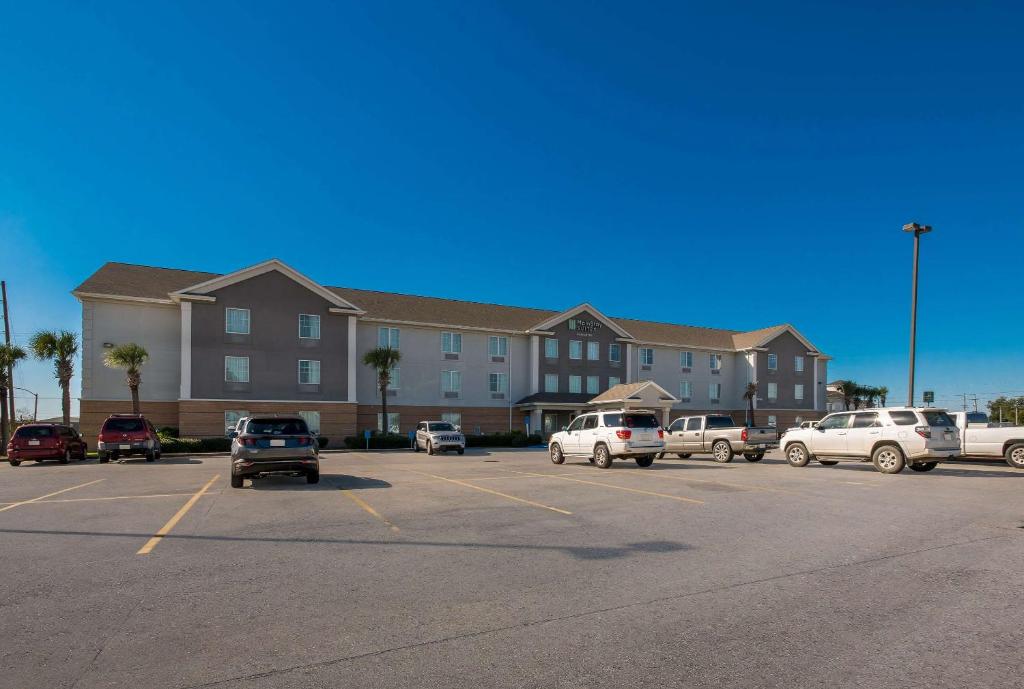 a parking lot with cars parked in front of a building at MainStay Suites Houma in Houma