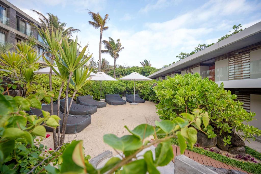 a courtyard with chairs and umbrellas and plants at Radisson Blu Poste Lafayette Resort & Spa (Adults Only) in Poste Lafayette
