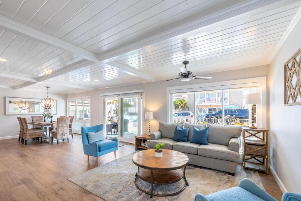 uma sala de estar com um sofá e uma mesa em Ocean Breeze I by AvantStay Steps to the Beach em Newport Beach