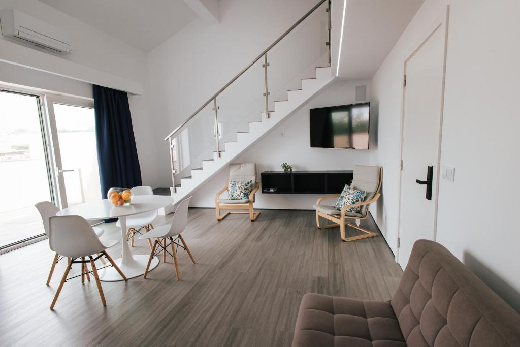 - un salon avec une table à manger et un escalier dans l'établissement Penthouse Seaside Apartment B - Faraway, à Lagoa