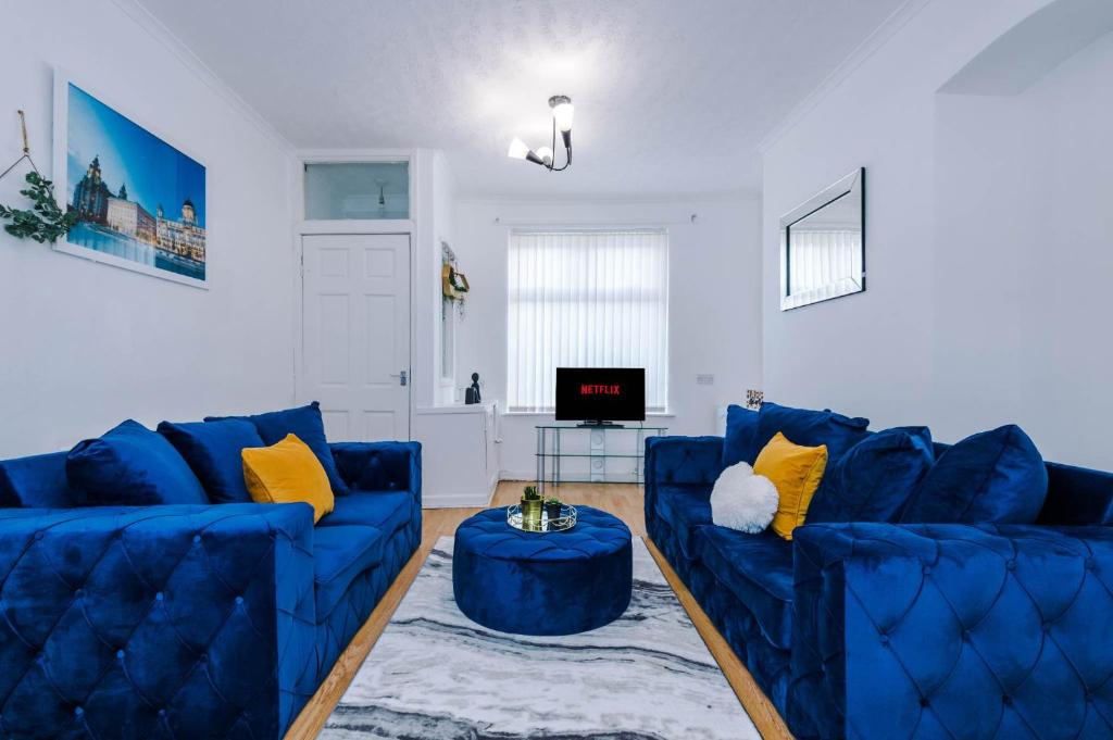 a living room with two blue couches and a table at Liverpool City Haven-Dane Street in Liverpool