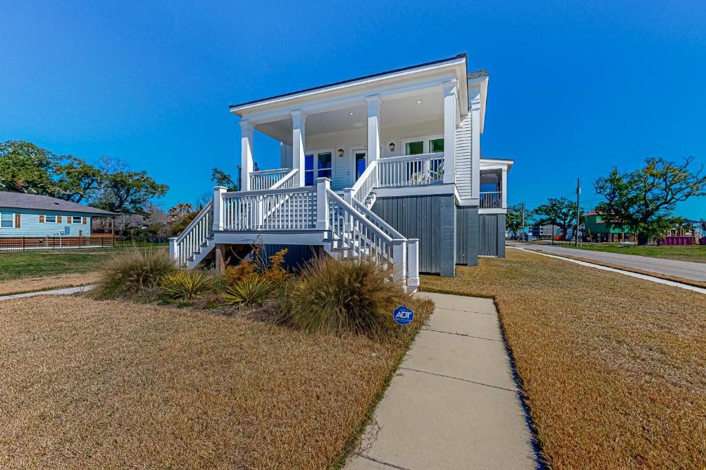a large house with white stairs on a street at The Ruth Retreat in Gulfport