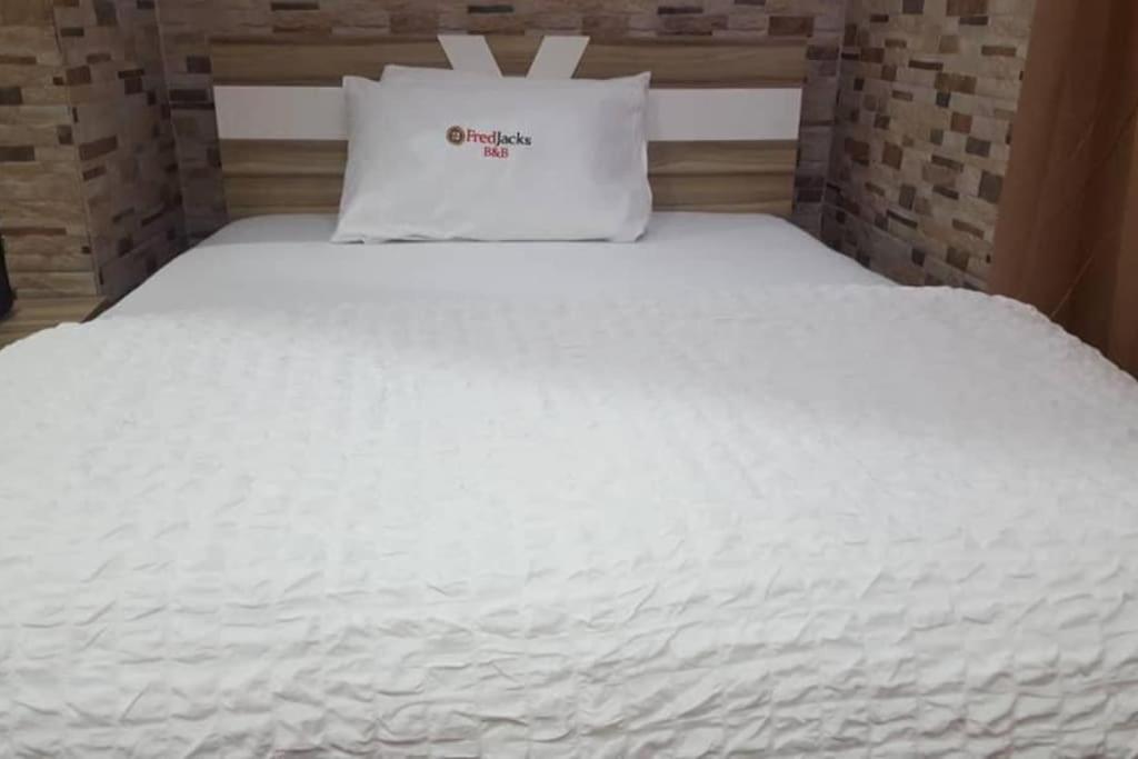 a white bed with a pillow on top of it at Cheerful and peaceful 4-bedrooms house in Koforidua