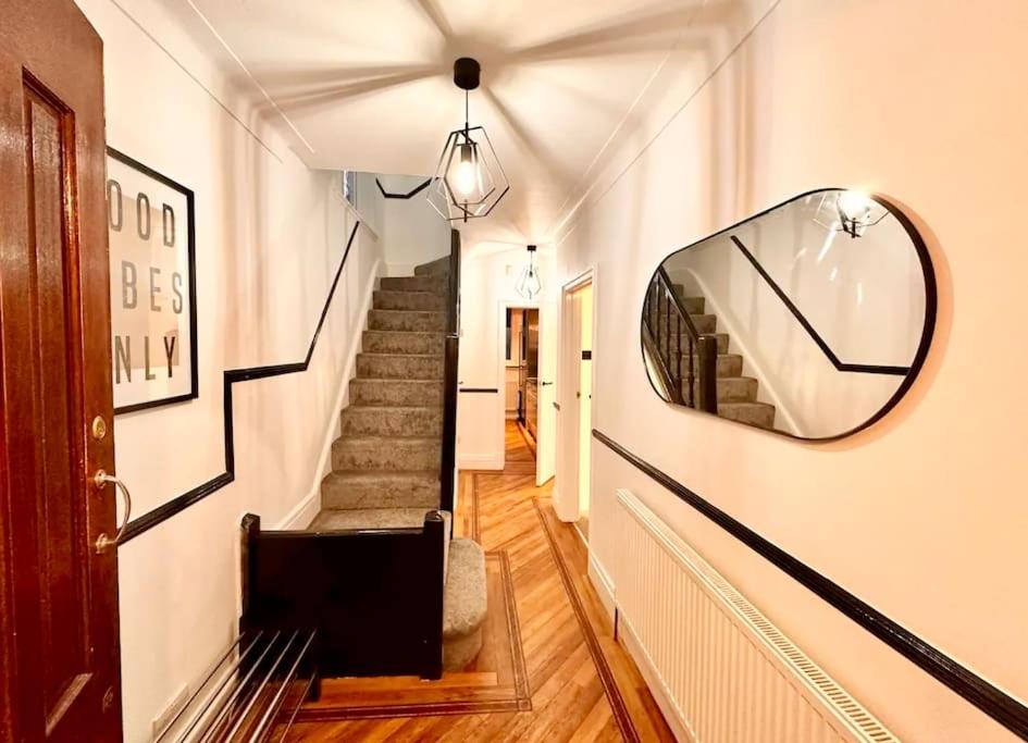 un pasillo con escaleras y un espejo en la pared en Wembley wow house, en Preston