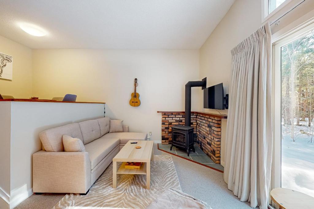 ein Wohnzimmer mit einem Sofa und einem TV in der Unterkunft Butternut Hill D4 in Waitsfield