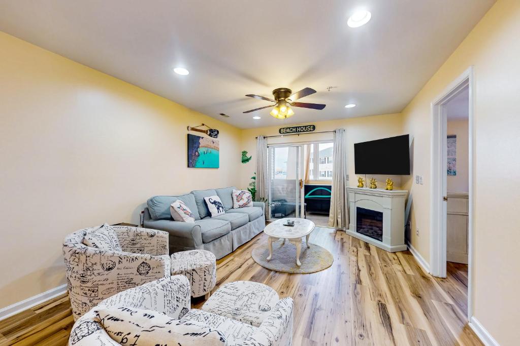a living room with a couch and a tv at The Palms --- 36507 Palm Dr #2203 in Rehoboth Beach