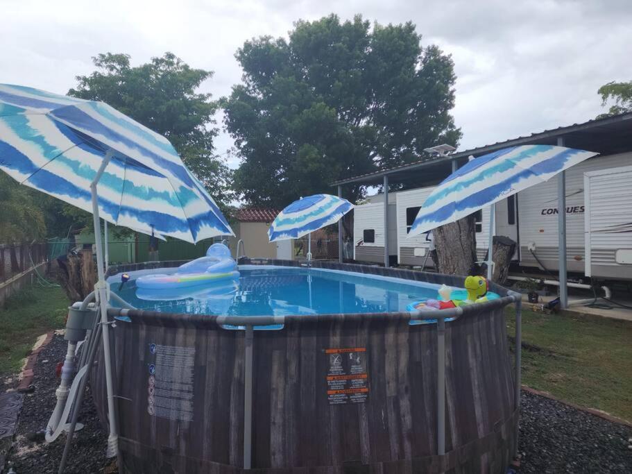 bañera de hidromasaje con 2 sombrillas y piscina en Kodesh Vacation Club, Boquerón Campers en Cabo Rojo