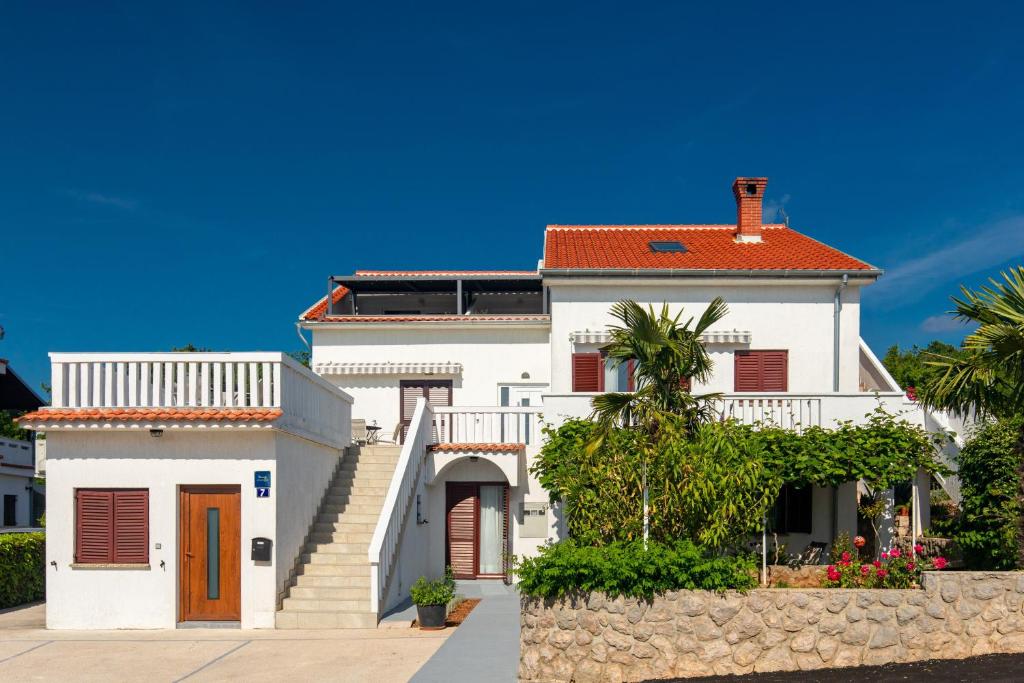 a white house with a red roof at Apartments and rooms with parking space Njivice, Krk - 17010 in Njivice