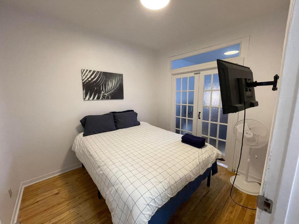a small bedroom with a bed and a television at 450$ 7nights // Full Kitchen // Room B in Montréal
