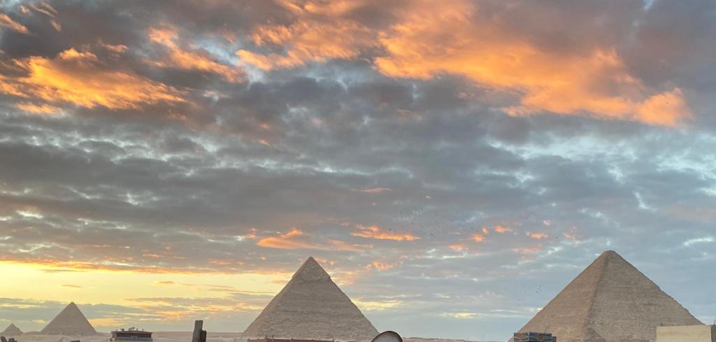 een groep piramides onder een bewolkte hemel bij 4 Pyramids inn in Caïro