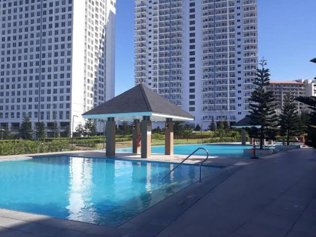 a large swimming pool with a gazebo in a city at BRENT CONDO UNIT WITH FREE PARKING & NETFLIX in Tagaytay
