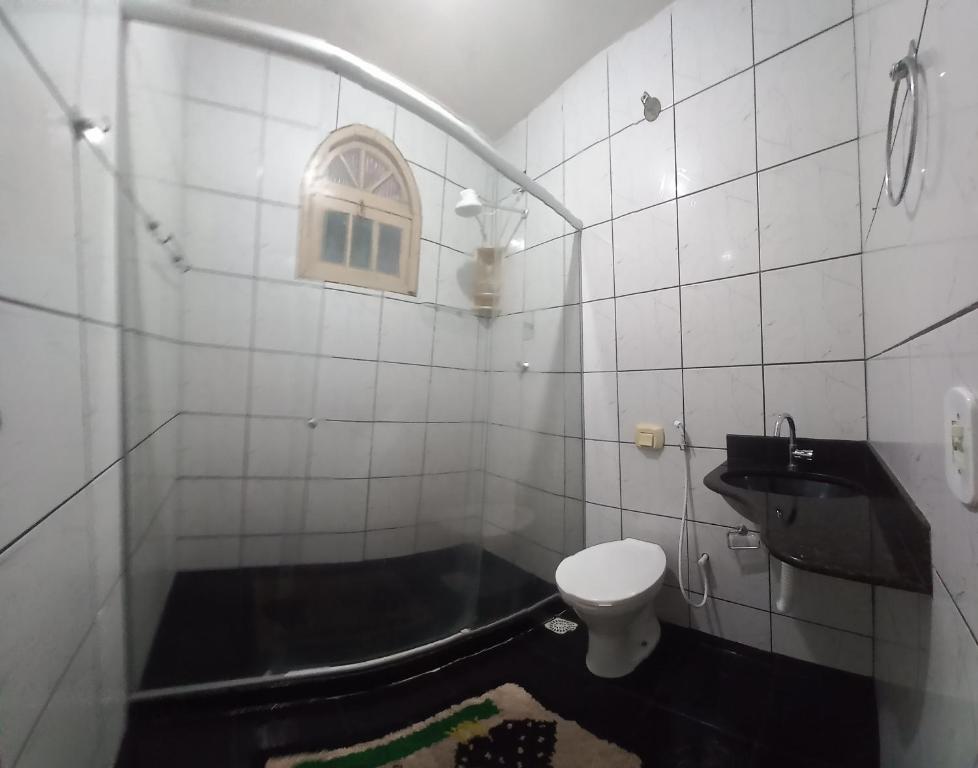 ein Badezimmer mit einer Badewanne, einem WC und einem Waschbecken in der Unterkunft Nossa Casa com Piscina in Guarapari