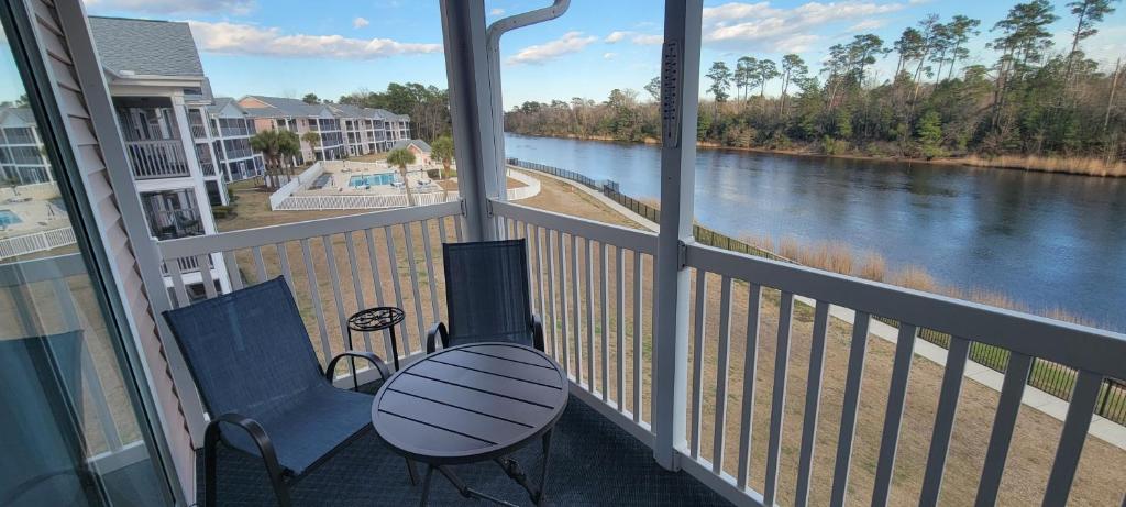 a balcony with a table and a view of a river at Myrtle Beach Waterway Getaway in Myrtle Beach