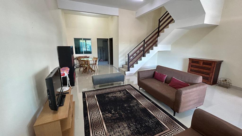 a living room with a couch and a television at Calm Home in Kuala Terengganu in Kuala Terengganu