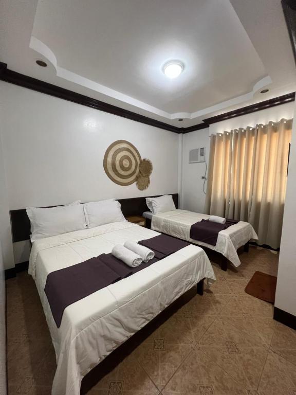 2 camas en una habitación de hotel con paredes blancas en Oceana Bay Coron en Corón