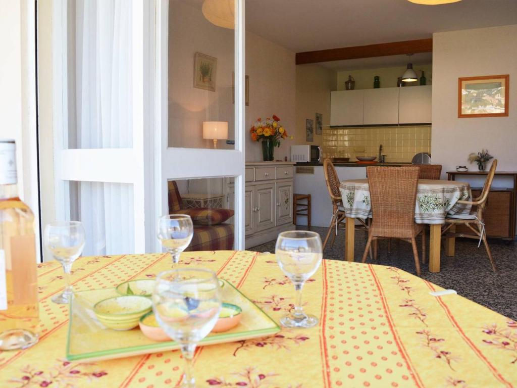 une table avec une assiette de nourriture et des verres à vin dans l'établissement Appartement avec Piscine, Tennis et Parking au Lavandou - 2 Pièces, 4 Couchages - FR-1-251-24, au Lavandou